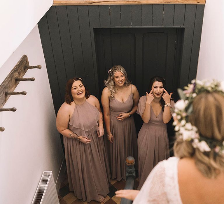 Bridesmaids in pink bridesmaid dresses seeing the bride for the first time 