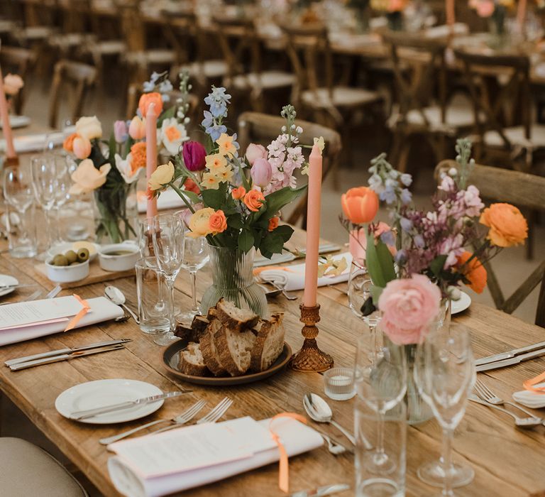 Pastel wedding table centrepieces on wood slice decor 