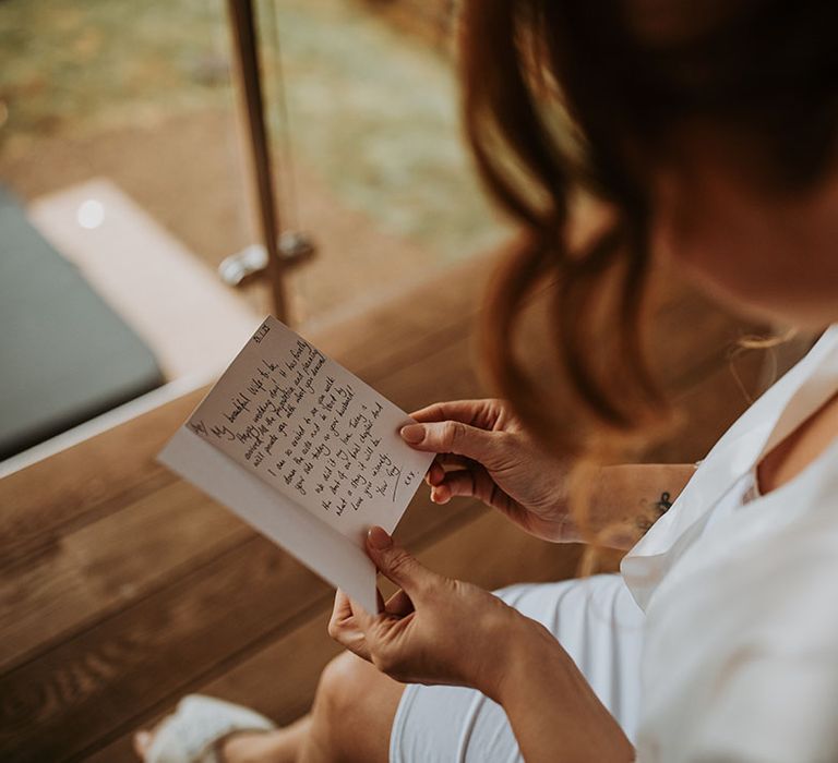 Bride reading her personal letter from the groom on the morning of her wedding 