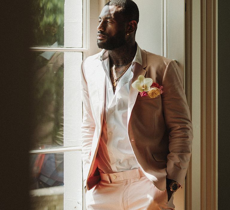 Baby pink groom suit with orchid buttonhole accessory 