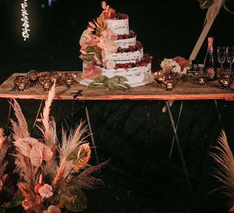 four tier semi naked wedding cake with mixed berry decoration 