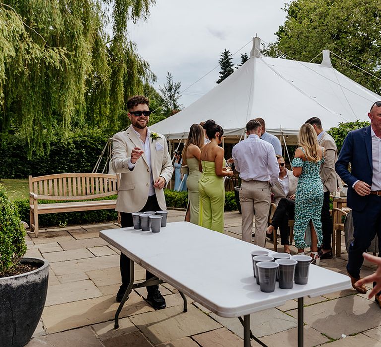 The wedding guests play beer pong game at modern wedding 