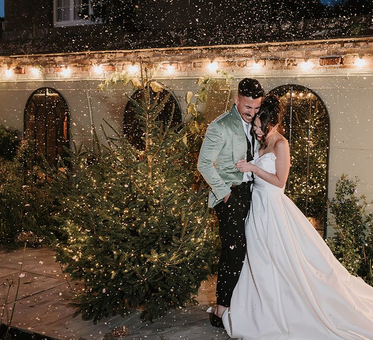 Country house wedding venue with the bride and groom at the winter Christmas wedding with Christmas tree 