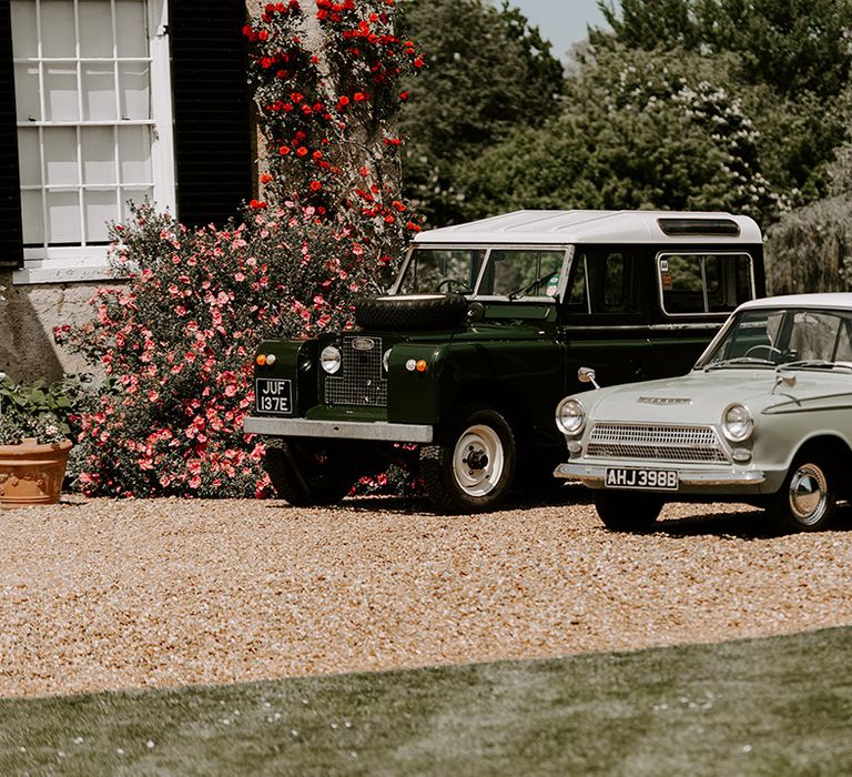 Vintage wedding cars parked outside of the country house wedding venue