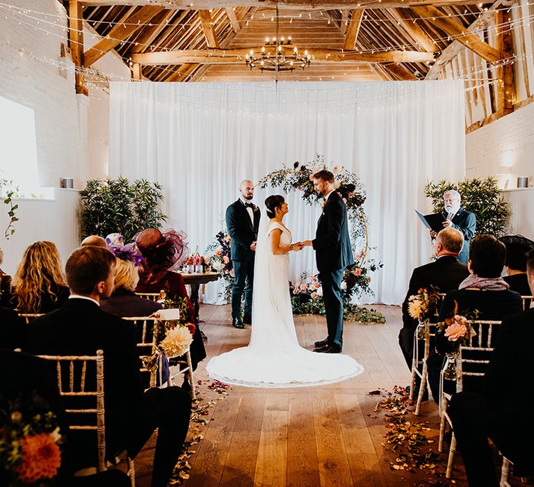 The Barn at Alswick wedding ceremony with floral moongate decor 