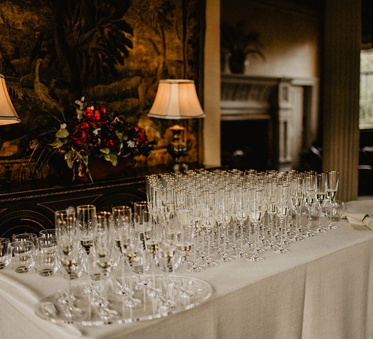 Gold rimmed champagne glasses on white table for the welcome drinks 