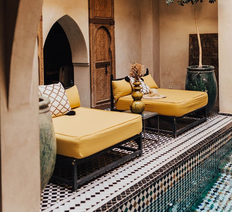 Yellow love seat lounging day beds at Moroccan wedding venue 