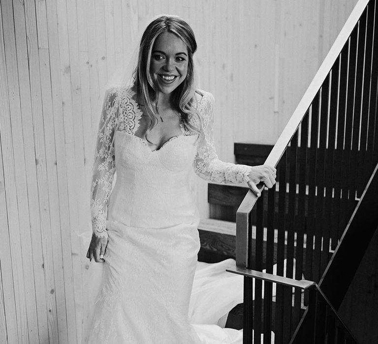 Bride in long sleeve delicate lace wedding dress for rustic barn wedding 