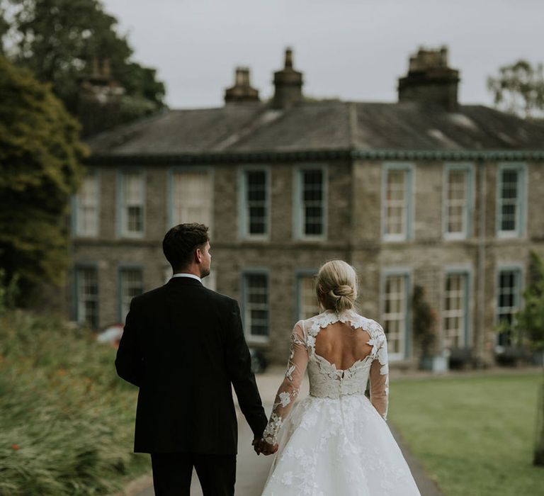 Bride wearing lace wedding dress with keyhole cutout with groom at Lake District wedding 