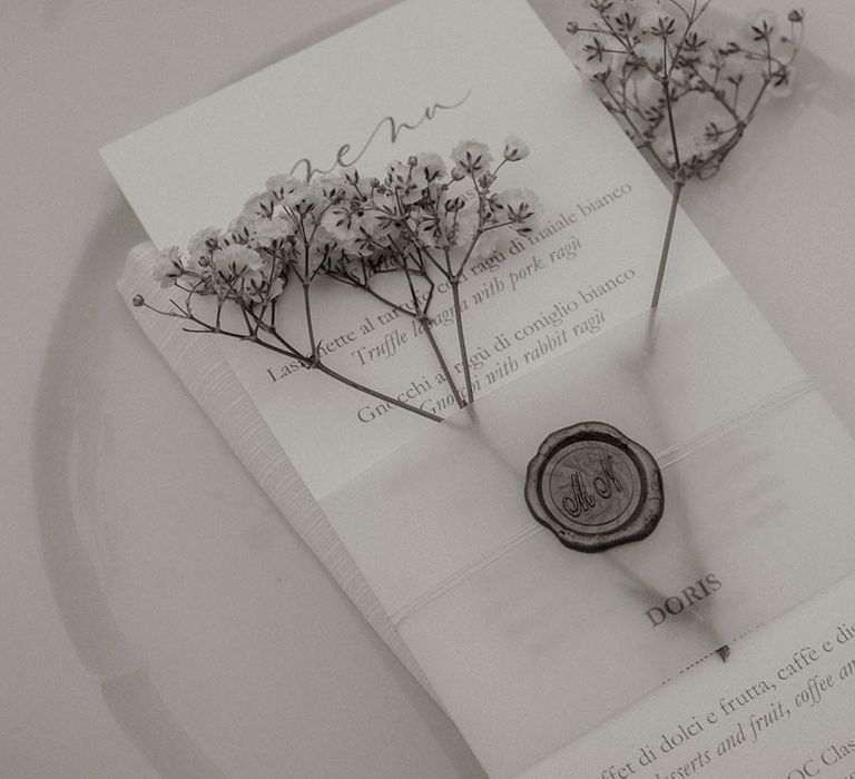 Simple monochrome wedding place setting with white stationery and personalised wax seal 