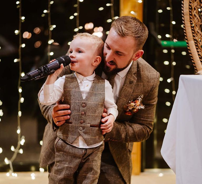 Groom in brown checkered suit with his son wearing brown suits at boho autumnal wedding 