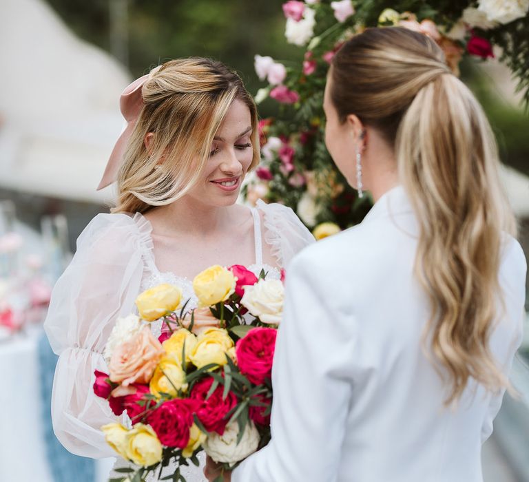 Two brides at LGBTQI same sex wedding in Positano, Italy with bright and colourful wedding bouquet 