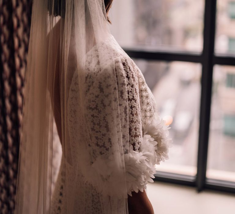 Bride in unique bespoke flower wedding dress with large pearl crown and veil 