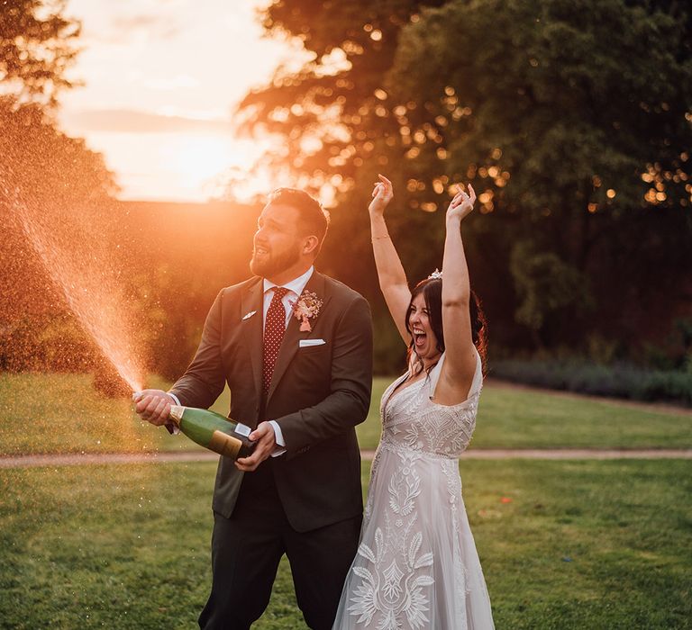 Champagne pop wedding photo for bride and groom during golden hour 