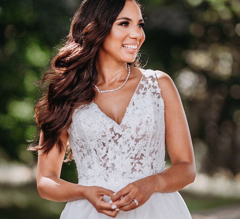 Bride smiling in floral lace wedding dress with diamond tennis necklace 