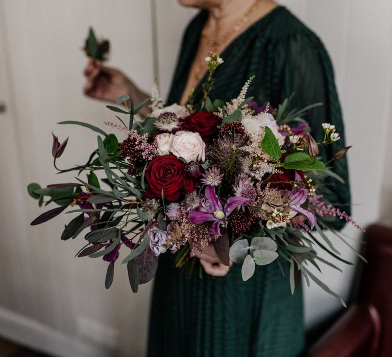 Red, pink and purple wedding bouquet with foliage 