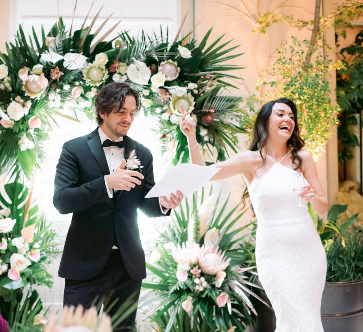 Newly-married couple enjoying speeches at their tropical themed wedding in London