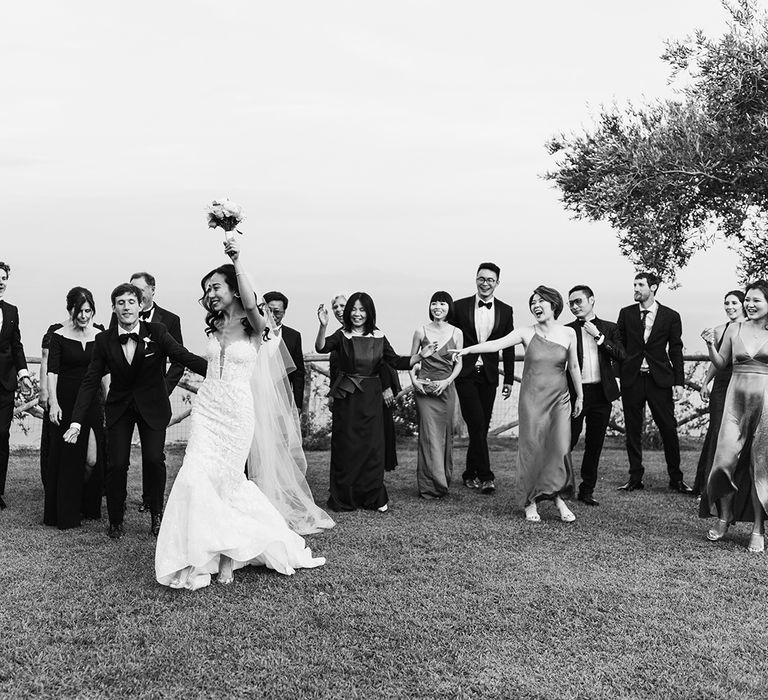 Bride in mermaid wedding dress dancing amongst the wedding party