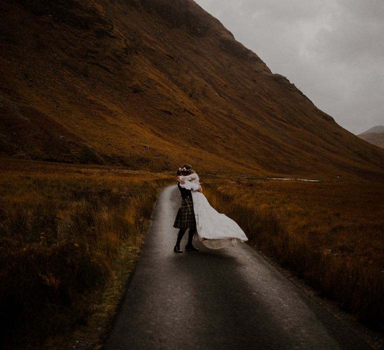 Bride and groom embrace outside in the highlands in Glencoe