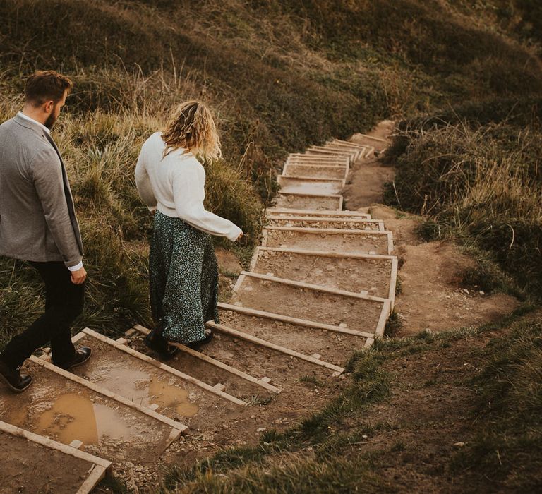 Bride and groom make their way to their Durdle Door Beach engagement shoot 