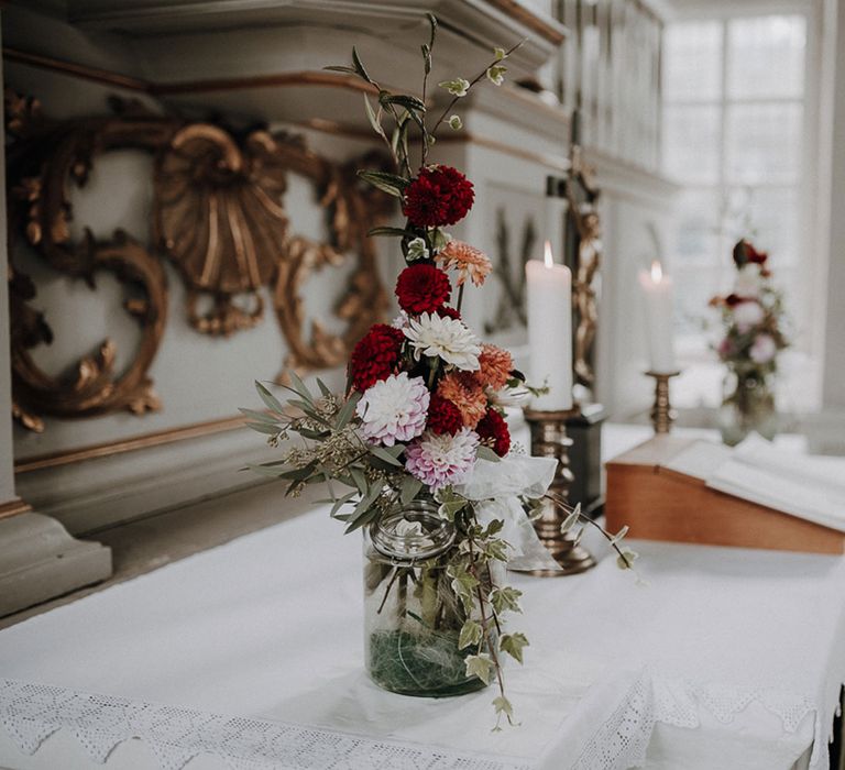 Red, orange and white wedding flower decor in German church ceremony