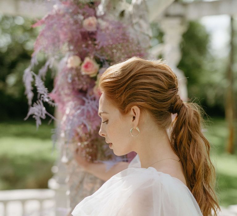 Bride wears her hair in a low ponytail 