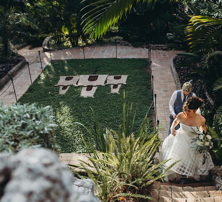 Bride in a strapless Wtoo wedding dress walking up the steps at Gibraltar Botanic Gardens