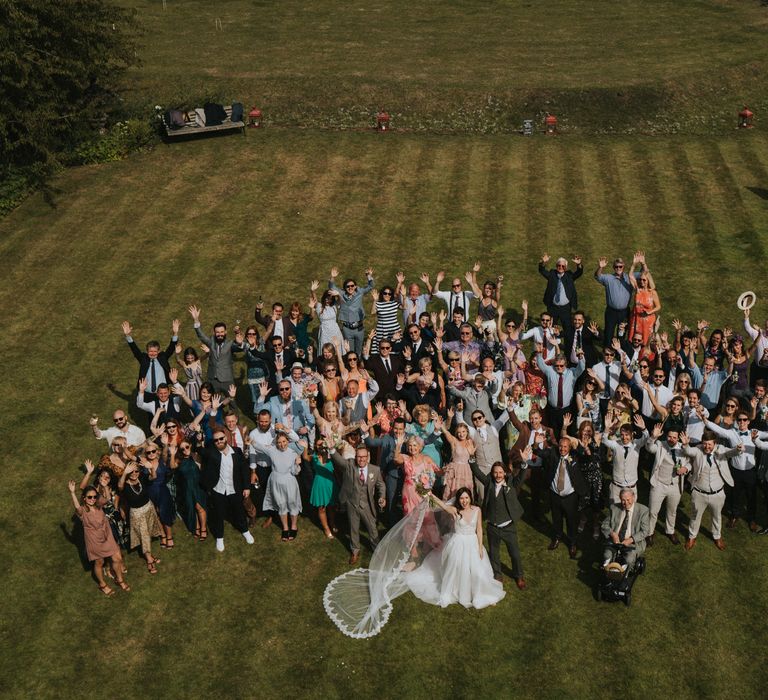 Wedding guests all gather on the lawn for photo 