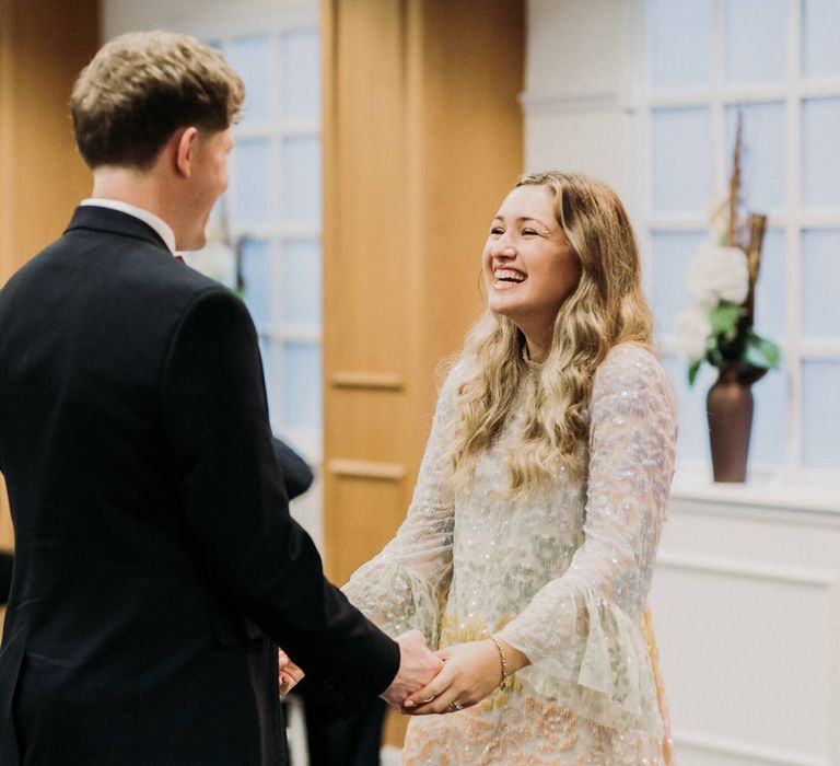 Bride and groom holding hands at wedding registry office 