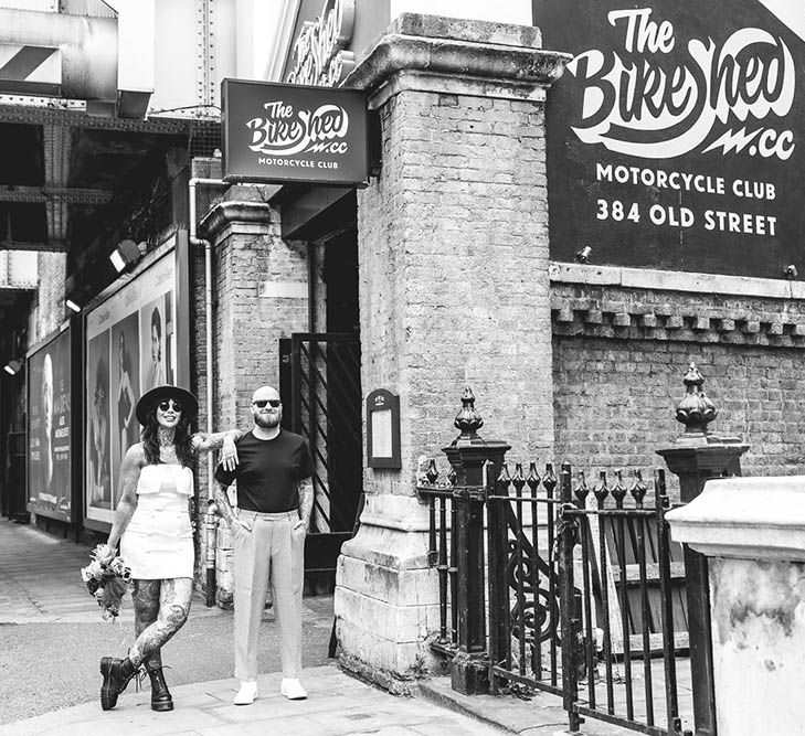 Black and white portrait of an alternative bride and groom outside The Bike Shed in Shoreditch 