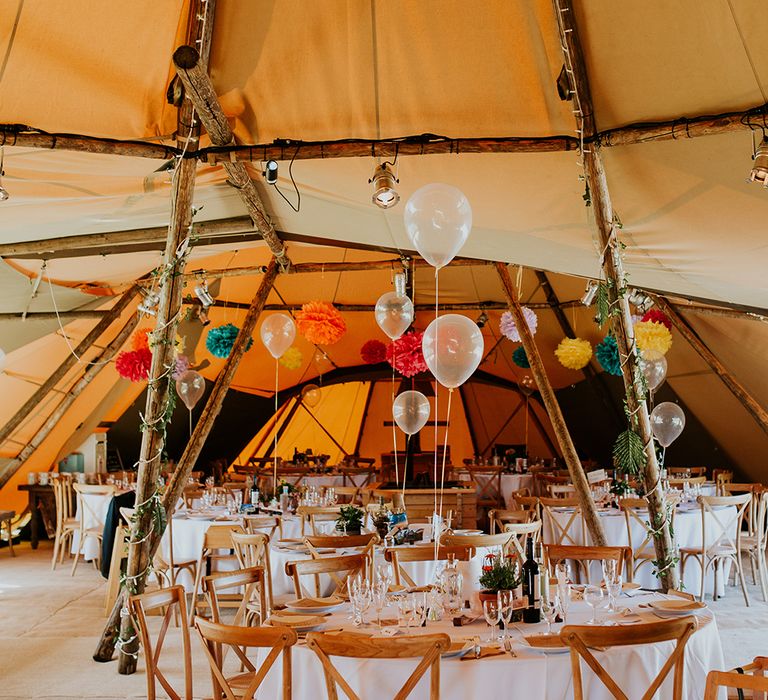 Bright & colourful tipi interior complete with disco ball and coloured balloons