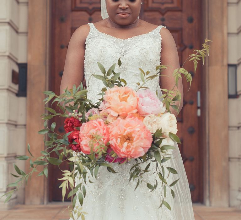 Bride carries bright floral bouquet on her wedding day