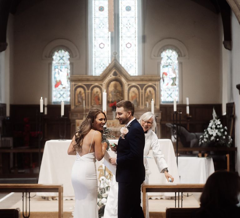 Bride and groom giggling at the altar as they get married