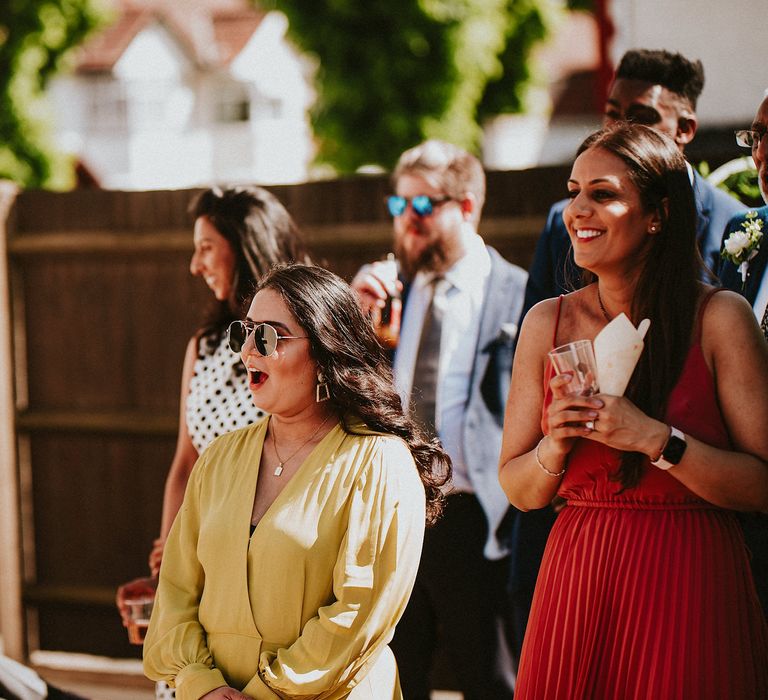 Wedding guests smiling during the garden party wedding speeches 