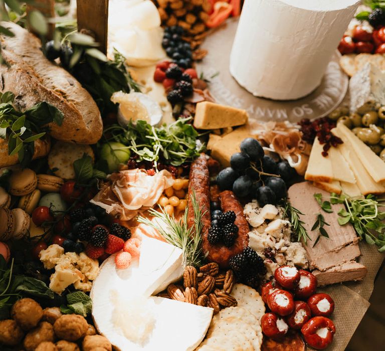 Grazing table by Char-Cuterie Boards by Charlotte, including breads, meats, cheeses, antipasti, herbs, macarons and fruit