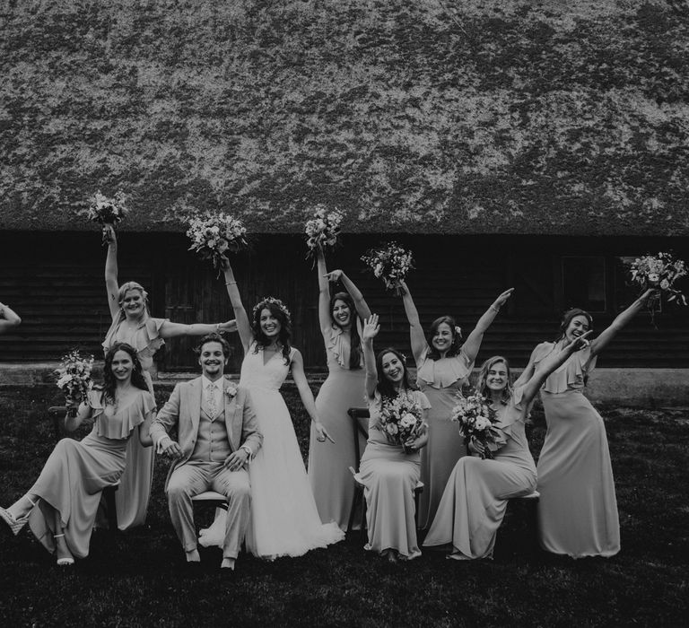 Black & white image of wedding party celebrating outdoors 