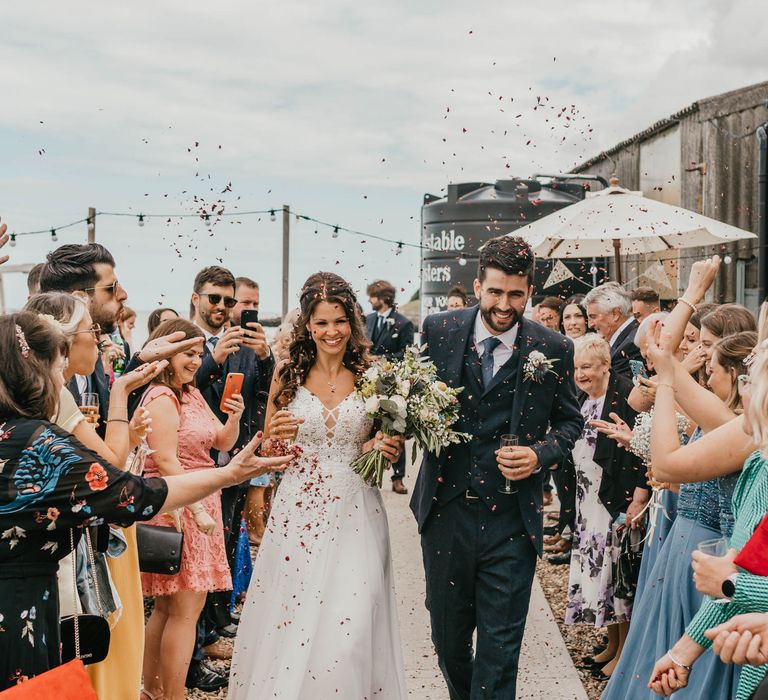 Bride & groom walk through confetti on their wedding day