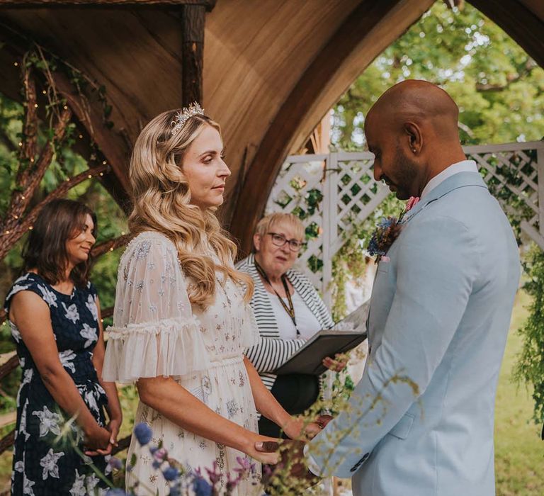 Bride & groom look lovingly at one another during spiritual ceremony