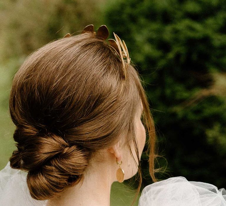 Bride with elegant pinned up wedding hairstyle wearing a gold headdress 