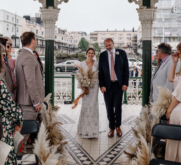 Bride walks down the aisle at coastal wedding in Brighton