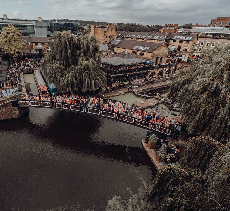 Wedding party gather across Camden Lock bridge for photo | Kim Williams Weddings