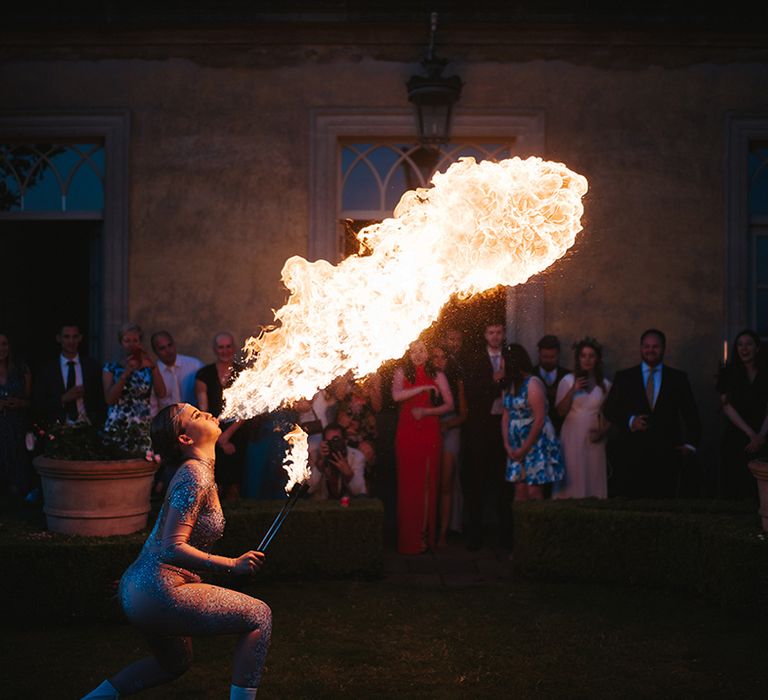 Fire dancer performs during wedding reception outdoors 