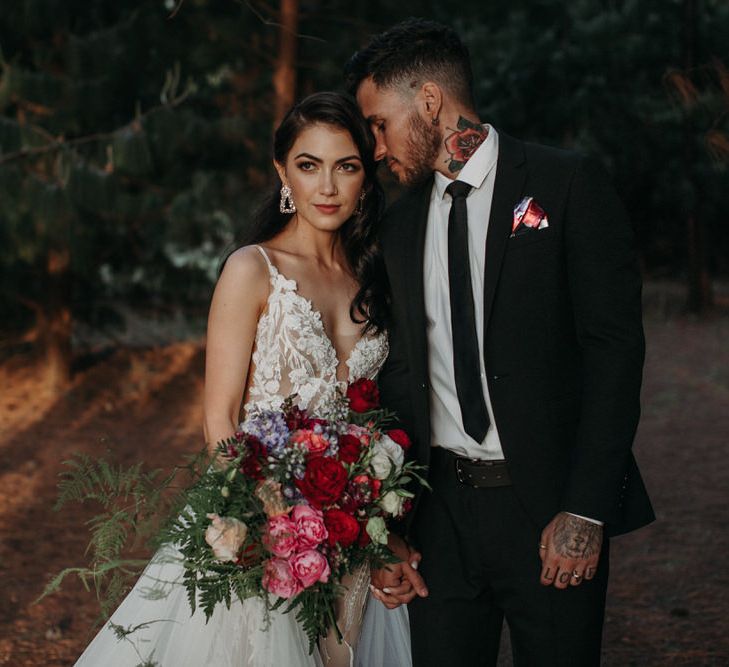 White brunette bride and white tattoo'd groom portrait with bride holding oversized deep pink bouquet