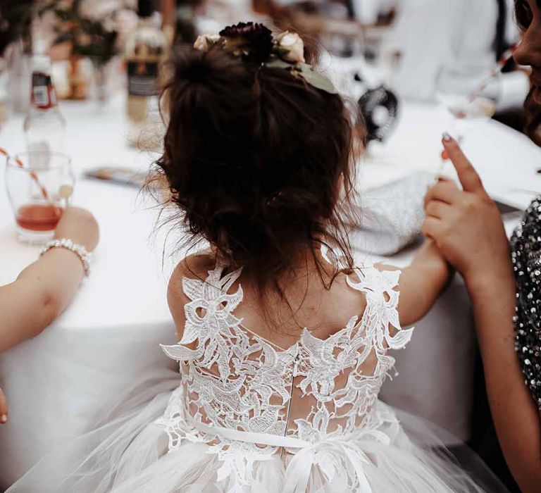 Flower girl wears lace detailed dress with chiffon bottom & ribbon tie