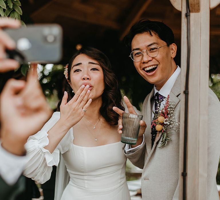 Bride & groom pose for selfie with wedding guest 