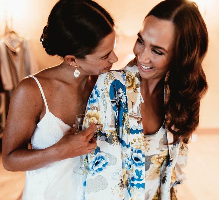 Bride hugs her bridesmaid on the morning of her wedding day