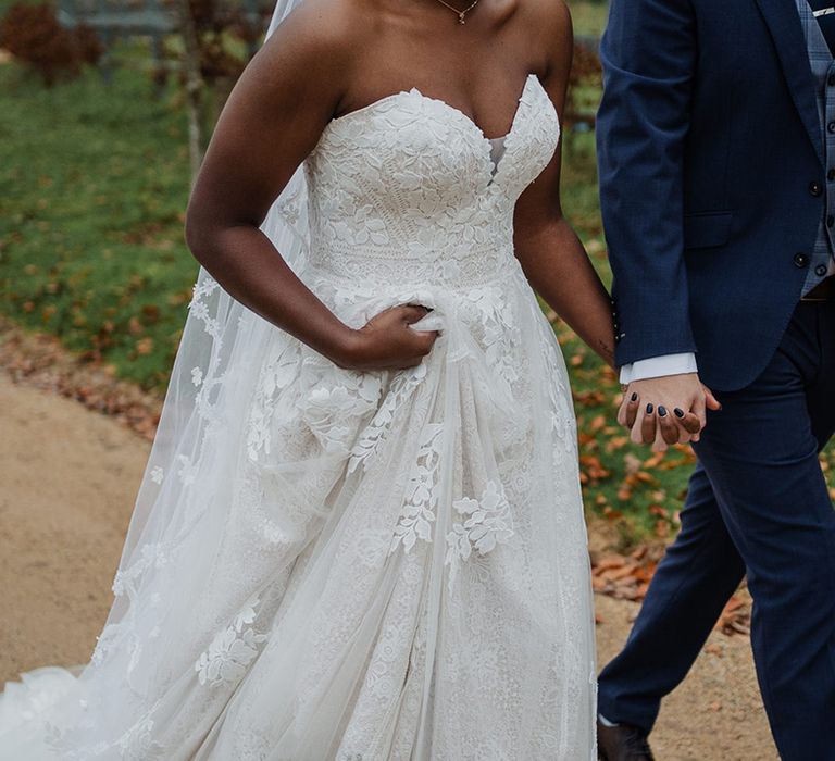 Bride wears layered wedding dress with sweetheart neckline and lace 