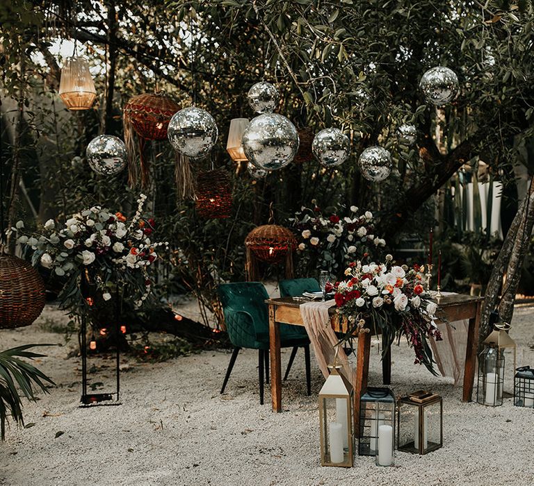 Outdoor area in Tulum, Mexico at Cenote Buho for bride and groom complete with candle lanterns and disco balls