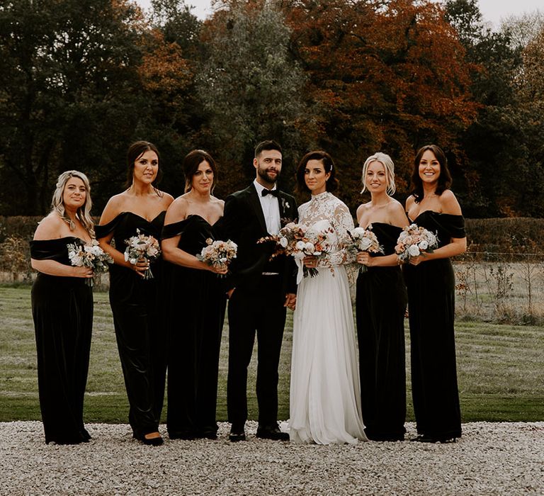 Bride and groom with bridesmaids in green velvet jumpsuits for winter wedding 