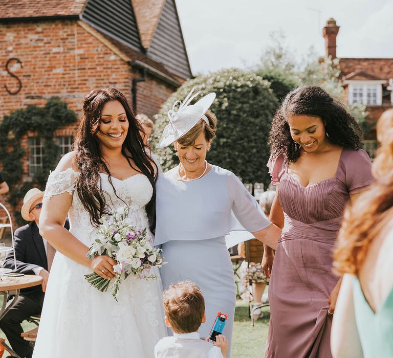 Bride, mother of the bride and bridesmaid are entertained by young page boy with Thomas the Tank Engine toy